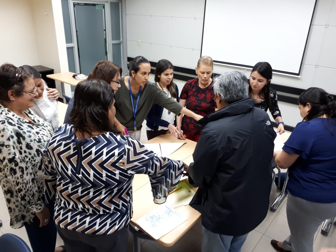 Grupo de Enfermería alrededor de una mesa, durante una actividad de devolución de resultados.