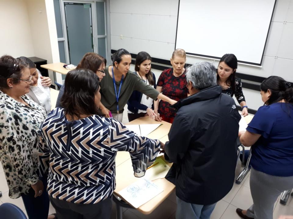 img-noticia-Grupo de Enfermería alrededor de una mesa, durante una actividad de devolución de resultados.